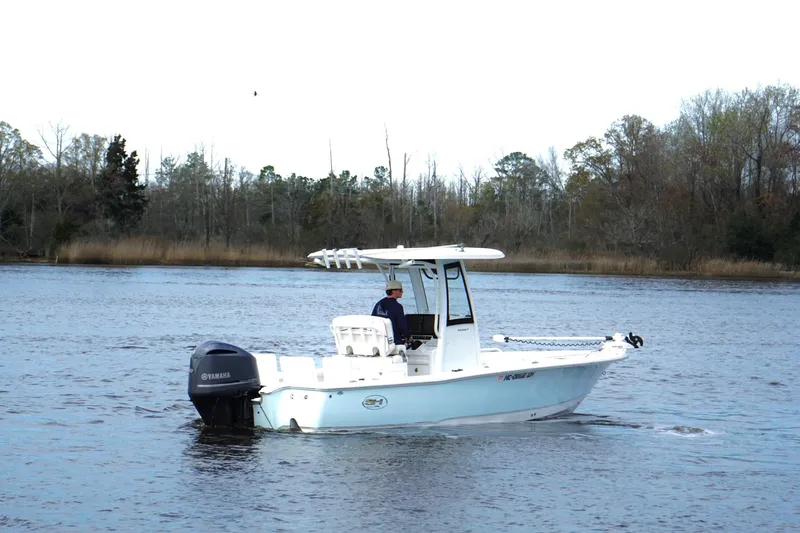 Slide: The Image of 2020 Sea Hunt BX 25 FS boat cruising on a calm river with trees in the background. - 4