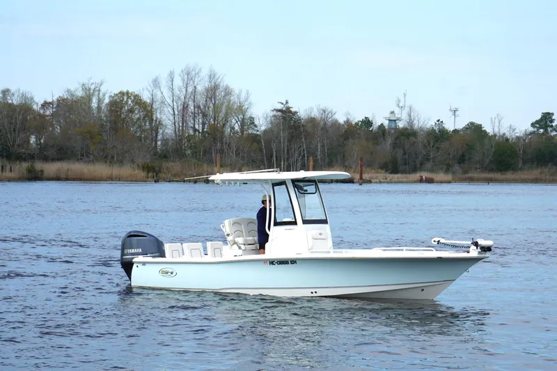 Slide: The Image of 2020 Sea Hunt BX 25 FS boat on calm water with trees in the background. - 5