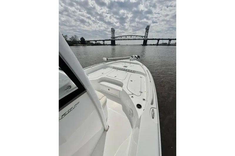 Slide: The Image of 2020 Sea Hunt BX 25 FS boat on water near a bridge under cloudy sky. - 8