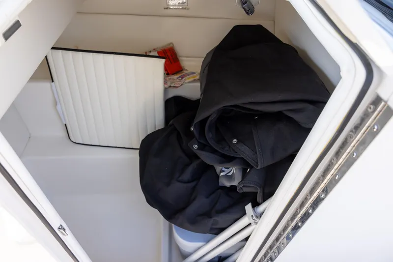 Slide: The Image of Storage compartment in 2021 Bayliner VR6 Bowrider OB with jackets and accessories. - 10