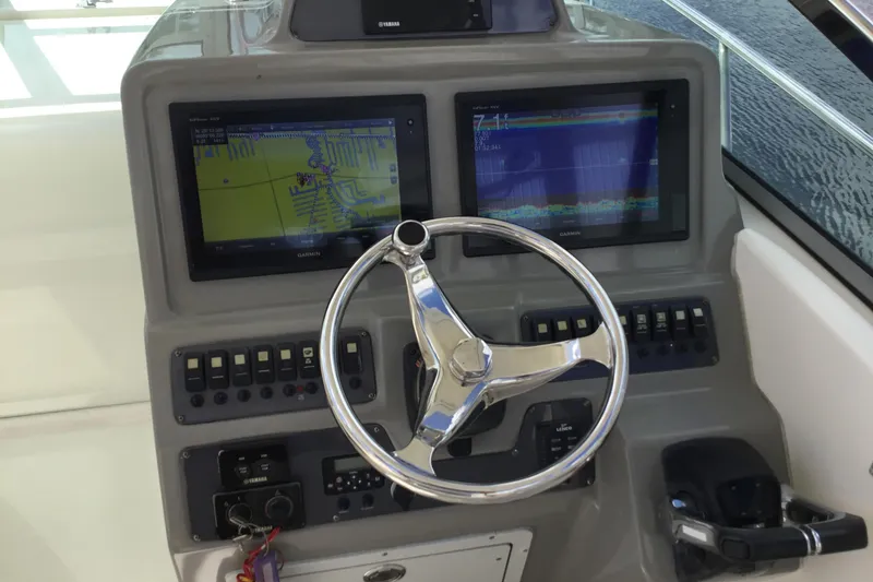 Slide: The Image of 2017 Robalo R305 Walkaround helm with dual Garmin displays and steering wheel. - 15