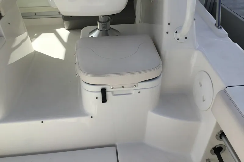 Slide: The Image of 2017 Robalo R305 Walkaround boat interior with cushioned seat and white finish. - 21