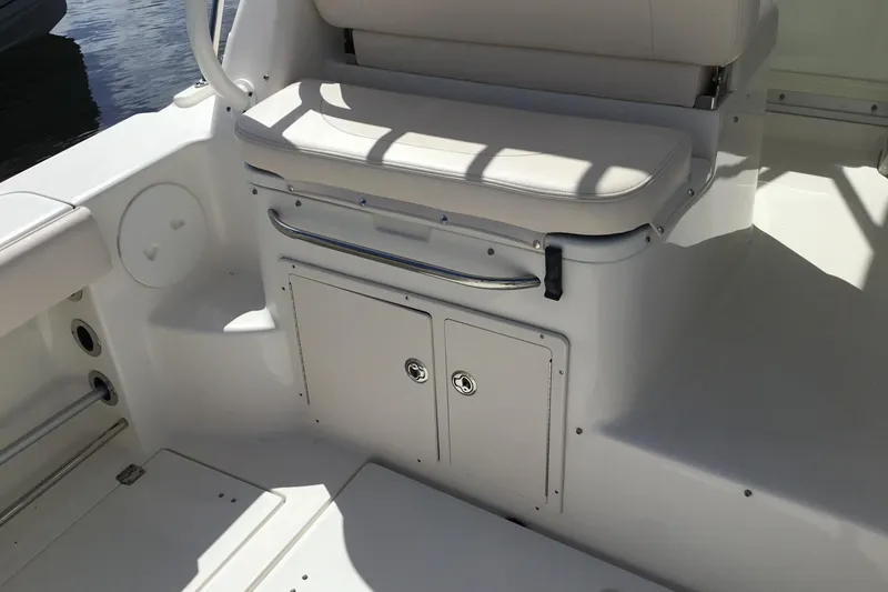 Slide: The Image of 2017 Robalo R305 Walkaround boat interior with cushioned seating and storage compartment. - 22