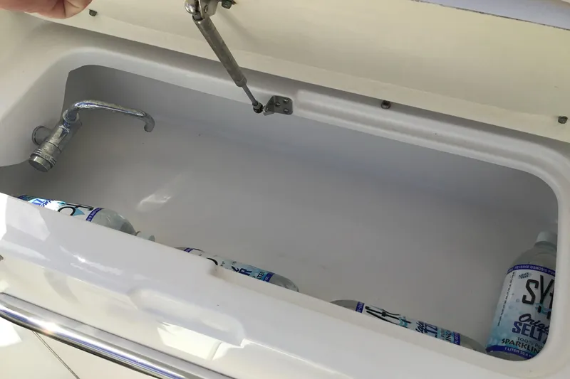 Slide: The Image of Open storage compartment with bottles in a 2017 Robalo R305 Walkaround boat. - 27