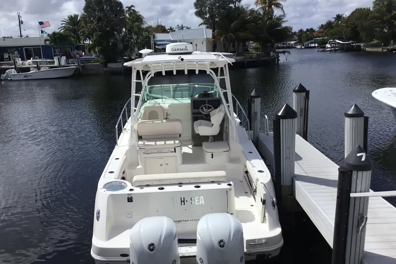 Slide: The Image of 2017 Robalo R305 Walkaround boat docked at marina with twin engines. - 3