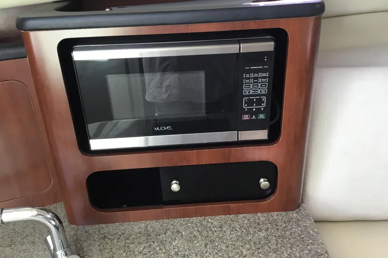 Slide: The Image of Microwave in 2017 Robalo R305 Walkaround boat kitchen with wood paneling. - 39