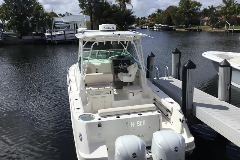 Slide: The Image of 2017 Robalo R305 Walkaround boat docked by a serene waterfront. - 46