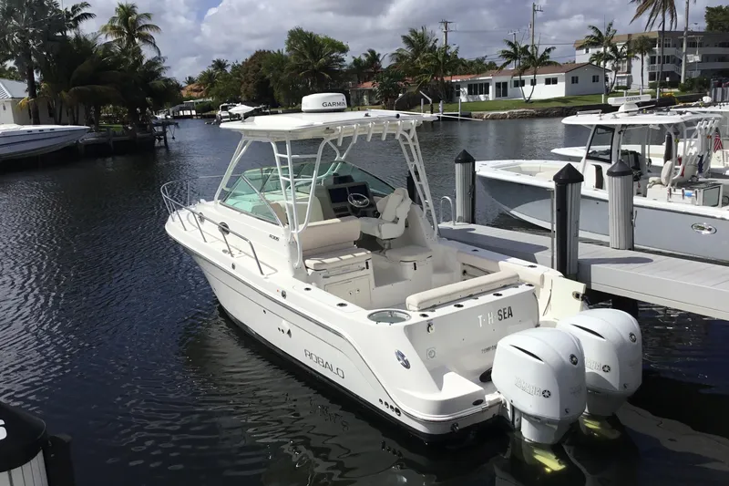 Slide: The Image of 2017 Robalo R305 Walkaround boat docked in a scenic marina setting. - 47
