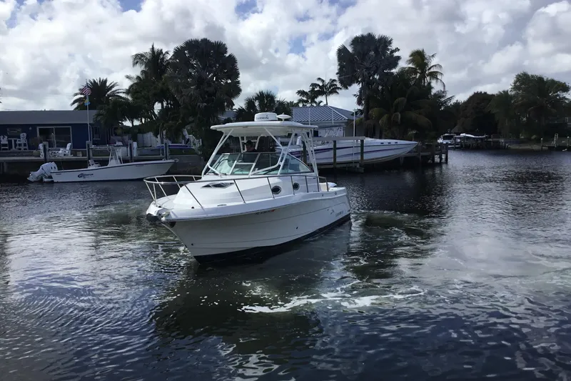 Slide: The Image of 2017 Robalo R305 Walkaround boat cruising in a scenic marina setting. - 52