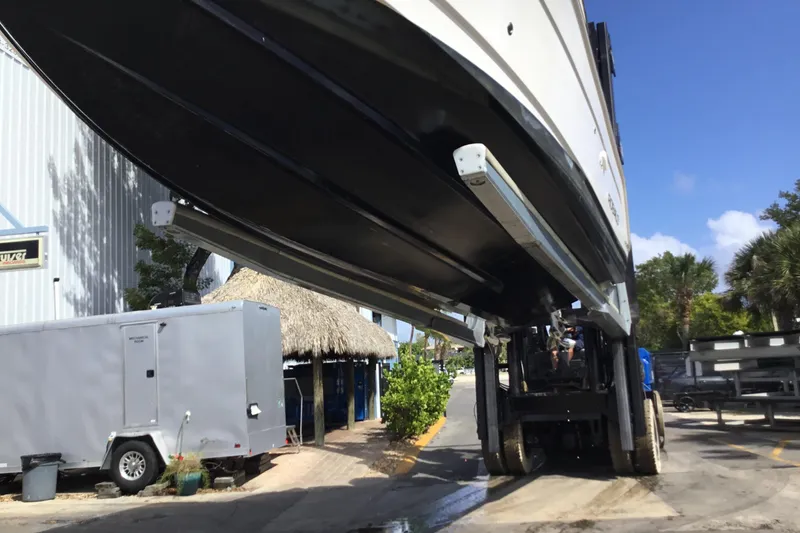 Slide: The Image of 2017 Robalo R305 Walkaround boat lifted by forklift at marina. - 54