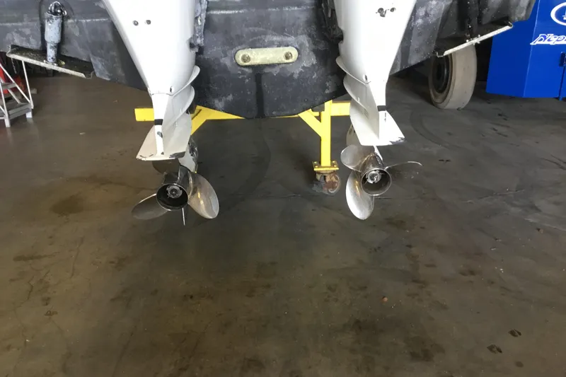 Slide: The Image of 2017 Robalo R305 Walkaround boat with dual propellers in a garage setting. - 55