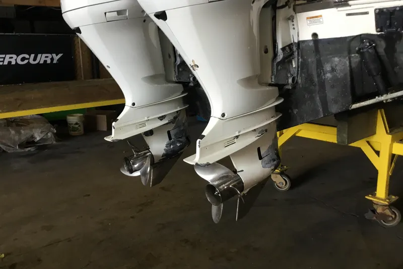 Slide: The Image of 2017 Robalo R305 Walkaround boat with dual outboard motors in a garage. - 57