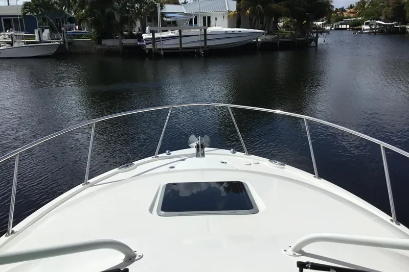 Slide: The Image of 2017 Robalo R305 Walkaround boat on calm water near docks and houses. - 7