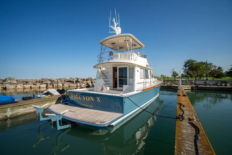 Slide: The Image of 2004 Grand Banks 58 Eastbay FB yacht docked in a marina under clear blue skies. - 8
