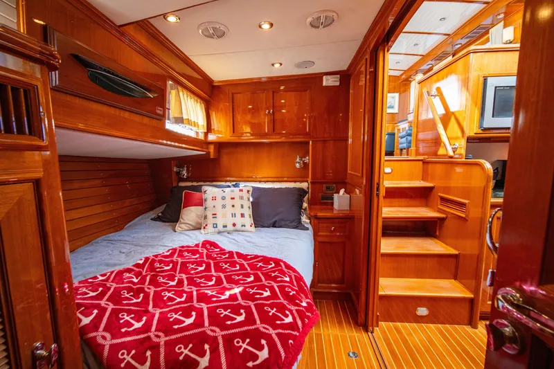 Slide: The Image of Luxurious cabin interior of 2004 Grand Banks 58 Eastbay FB yacht, featuring wooden finishes and cozy bedding. - 42