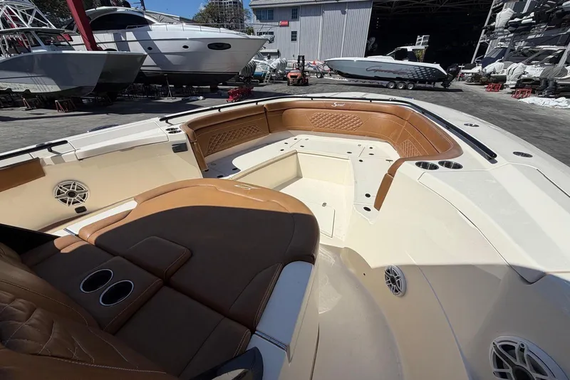 Slide: The Image of 2021 Scout 330 LXF boat interior with tan leather seating and cup holders. - 10