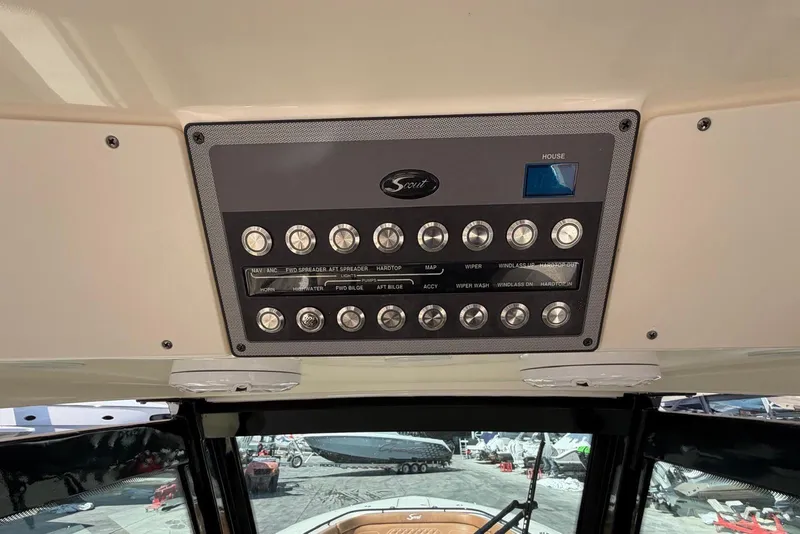 Slide: The Image of Control panel of a 2021 Scout 330 LXF boat with various switches and buttons. - 24