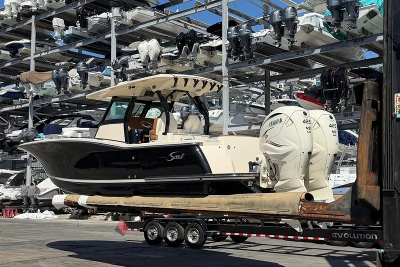 Slide: The Image of 2021 Scout 330 LXF boat on trailer with Yamaha engines in storage facility. - 3