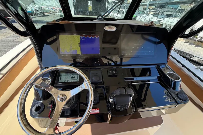 Slide: The Image of 2021 Scout 330 LXF boat dashboard with navigation screens and steering wheel. - 5