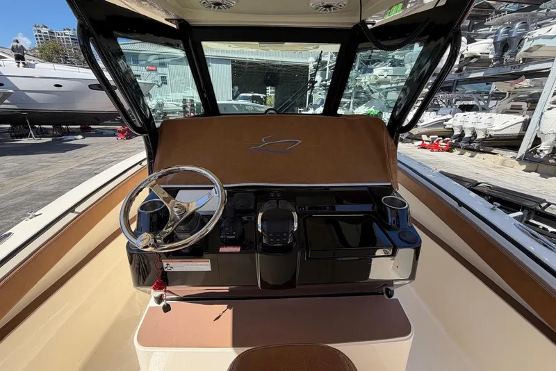 Slide: The Image of 2021 Scout 330 LXF boat helm with steering wheel and controls. - 7