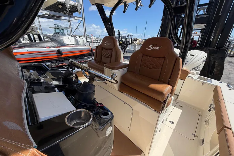 Slide: The Image of 2021 Scout 330 LXF boat interior with luxurious brown leather seating and modern controls. - 8