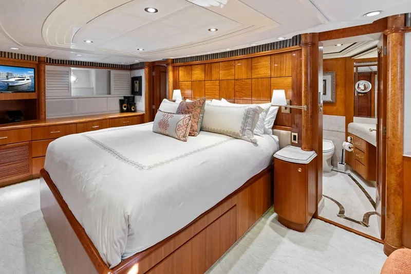 Slide: The Image of Luxurious 2001 West Bay Sonship yacht bedroom with elegant wood finishes and en-suite bathroom. - 12