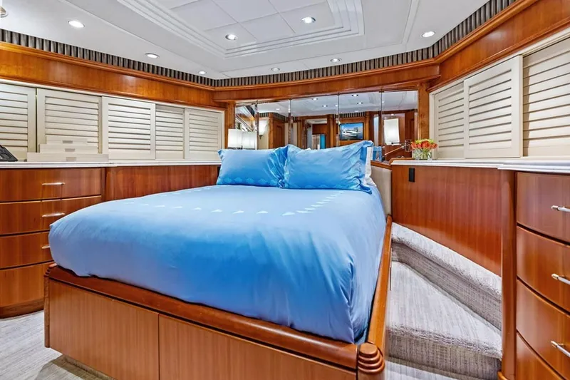 Slide: The Image of Luxurious 2001 West Bay Sonship yacht bedroom with blue bedding and elegant wood finishes. - 17