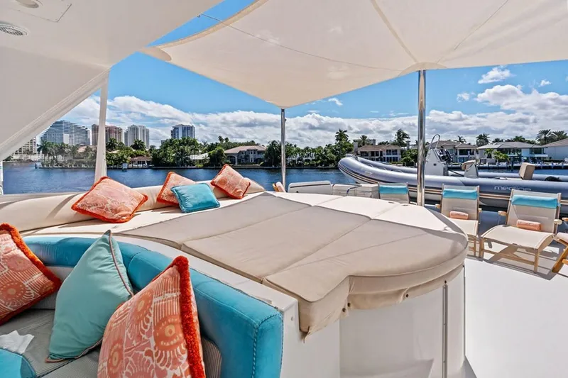 Slide: The Image of Luxurious 2001 West Bay Sonship yacht deck with plush seating and scenic waterfront view. - 22