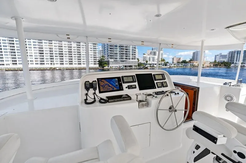 Slide: The Image of 2001 West Bay Sonship yacht helm with modern navigation equipment, overlooking waterfront cityscape. - 26