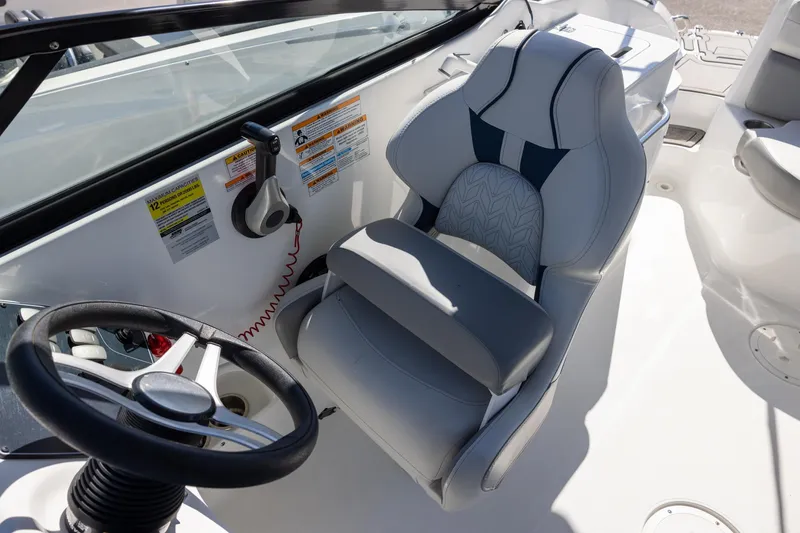 Slide: The Image of 2023 Hurricane SunDeck 2400 OB boat interior with steering wheel and captain's chair. - 10