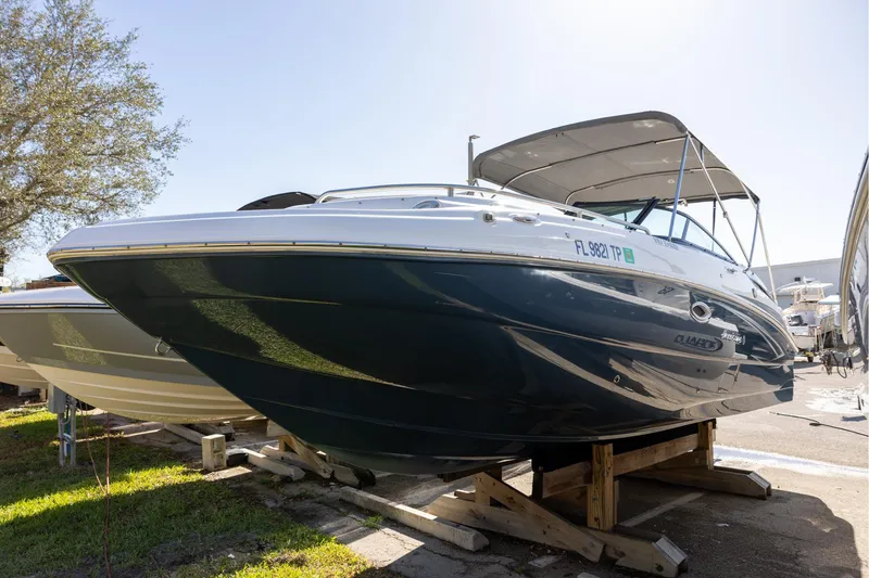 Slide: The Image of 2023 Hurricane SunDeck 2400 OB boat on display, featuring sleek design and canopy. - 2