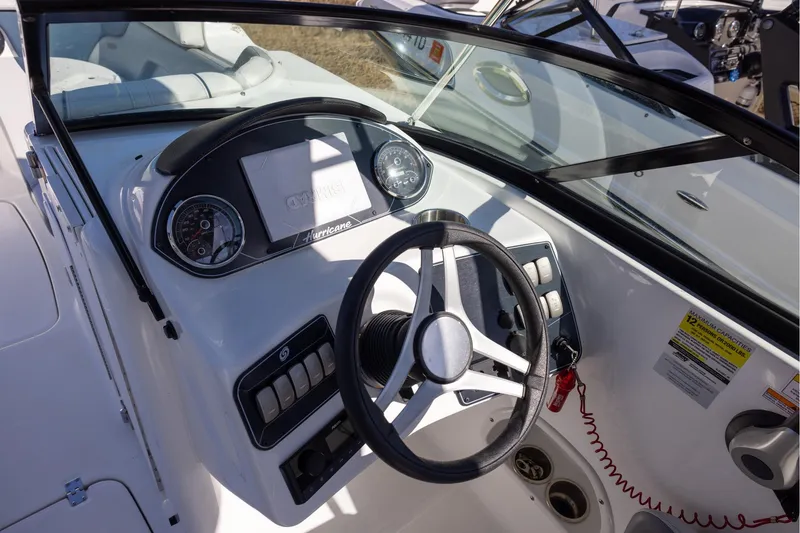 Slide: The Image of 2023 Hurricane SunDeck 2400 OB boat dashboard with steering wheel and controls. - 8