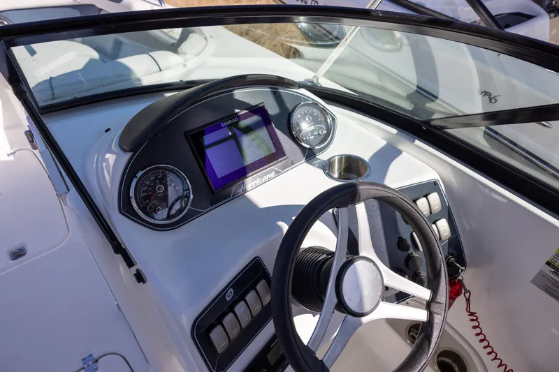 Slide: The Image of 2023 Hurricane SunDeck 2400 OB boat dashboard with steering wheel and digital display. - 9