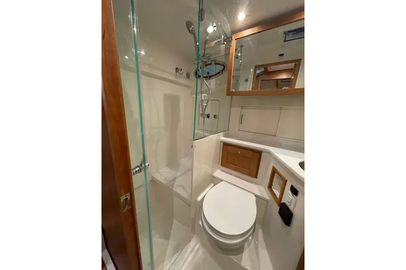 Slide: The Image of 2026 Back Cove 372 yacht bathroom with glass shower, modern fixtures, and wooden accents. - 18