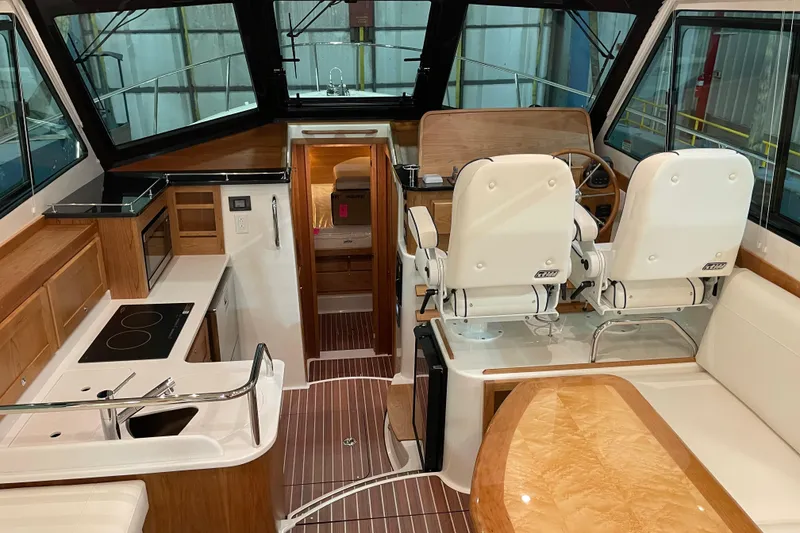 Slide: The Image of Interior of 2026 Back Cove 372 yacht with modern helm, kitchen, and seating area. - 9
