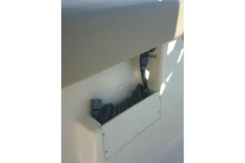 Slide: The Image of 2021 Key West 239 FS boat detail showing a coiled hose storage compartment. - 39