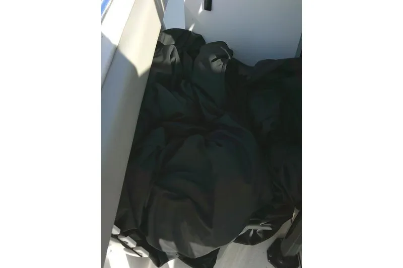 Slide: The Image of 2021 Key West 239 FS boat interior with black cover, sunlight casting shadows. - 48