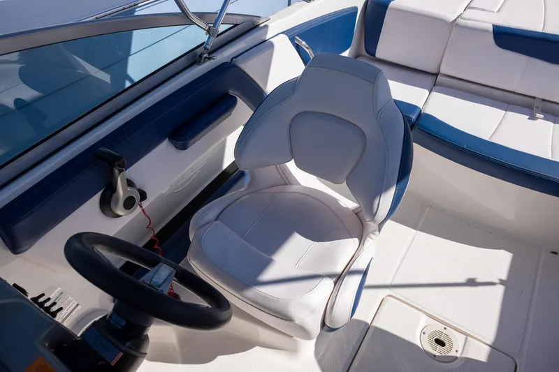 Slide: The Image of 2018 Chaparral 21 H2O Sport OB boat interior with steering wheel and seating. - 8