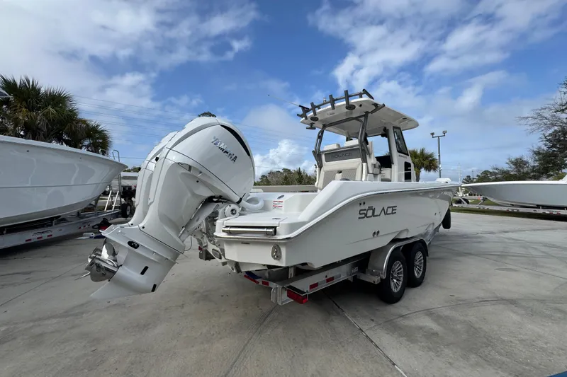 Slide: The Image of 2026 Solace 28 HCS boat with Yamaha engine on trailer, parked outdoors. - 11