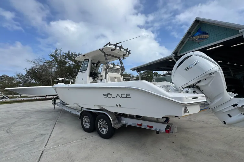 Slide: The Image of 2026 Solace 28 HCS boat on trailer with Yamaha engine, parked outdoors. - 16