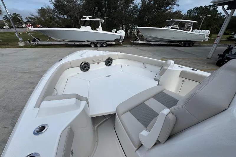 Slide: The Image of 2026 Solace 28 HCS boat interior with seating and speakers, parked on a trailer. - 18