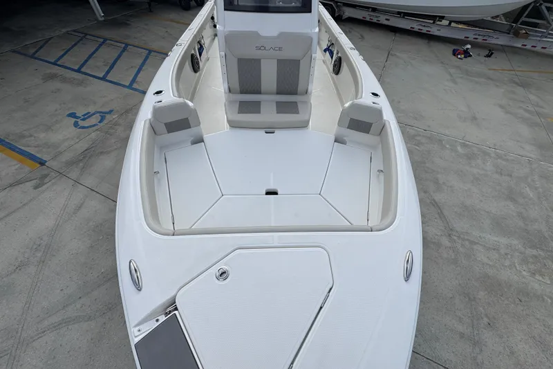 Slide: The Image of 2026 Solace 28 HCS boat, white deck, spacious seating, docked on concrete surface. - 19
