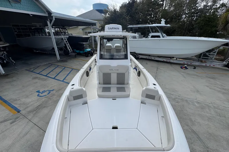 Slide: The Image of 2026 Solace 28 HCS boat in marina, featuring Garmin equipment and spacious deck. - 20