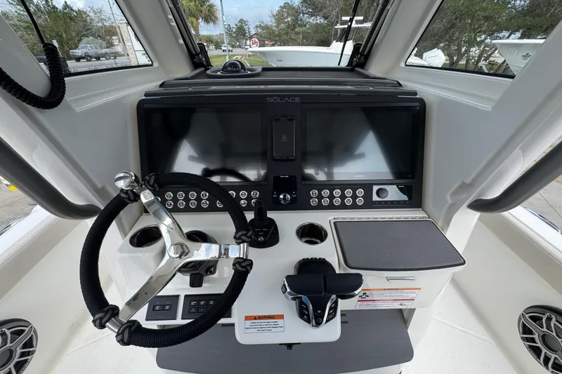 Slide: The Image of 2026 Solace 28 HCS boat dashboard with steering wheel and advanced controls. - 28
