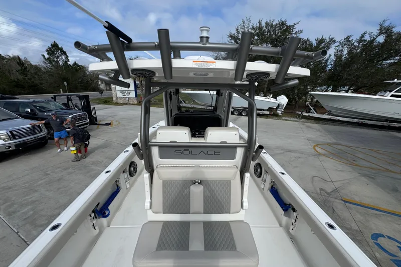 Slide: The Image of 2026 Solace 28 HCS boat interior with seating and rod holders, parked at a marina. - 33