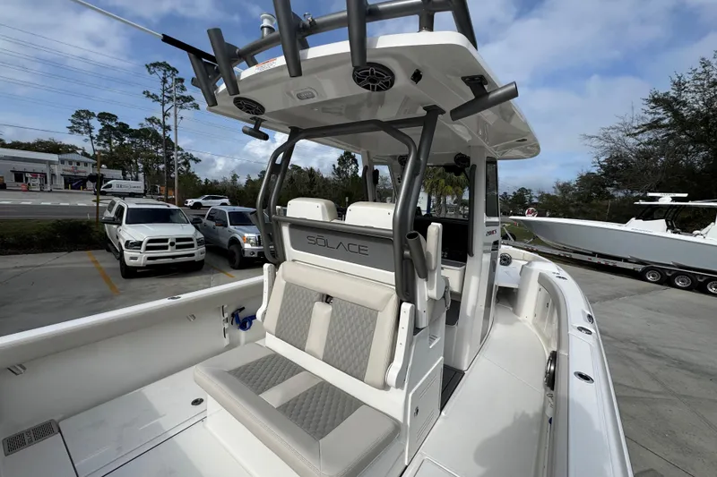 Slide: The Image of 2026 Solace 28 HCS boat with modern seating and sleek design in a parking lot. - 34