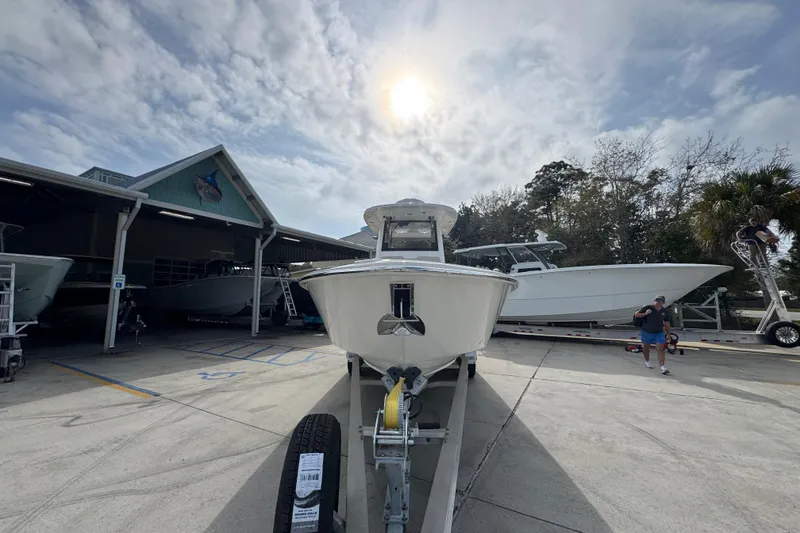 Slide: The Image of 2026 Solace 28 HCS boat on trailer under cloudy sky at marina. - 5