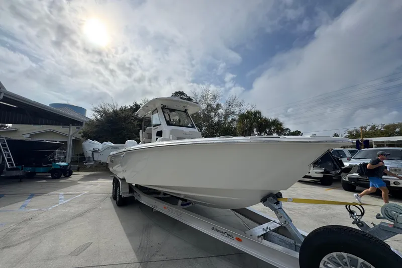 Slide: The Image of 2026 Solace 28 HCS boat on trailer under cloudy sky at dealership. - 6