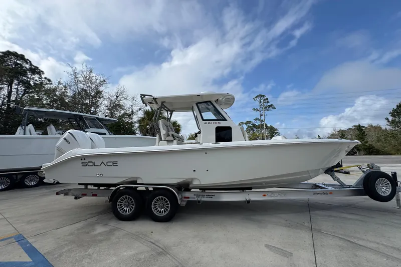Slide: The Image of 2026 Solace 28 HCS boat on trailer under cloudy sky, side view. - 8