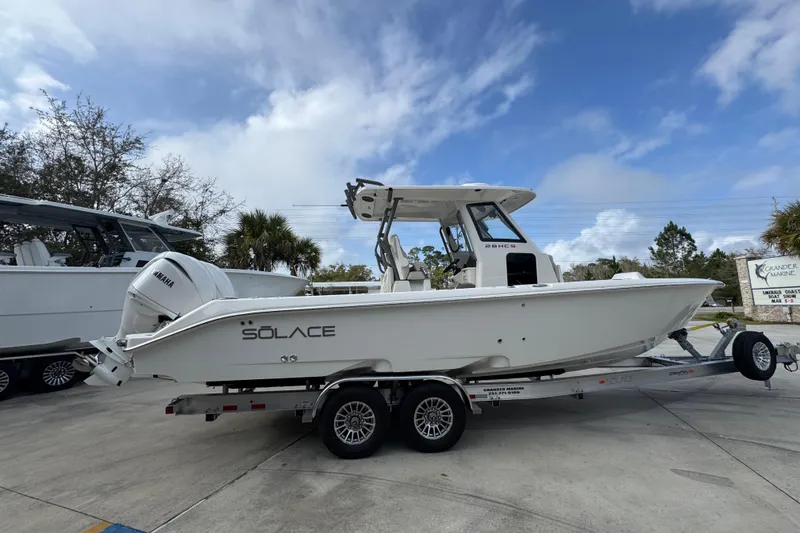 Slide: The Image of 2026 Solace 28 HCS boat on trailer, featuring Yamaha engine, parked outdoors. - 9